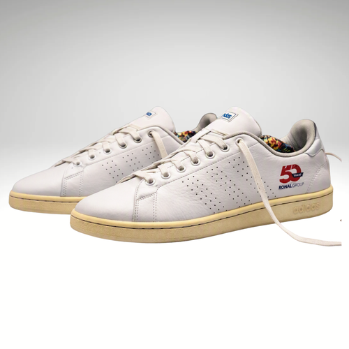 A pair of white leather Adidas Samba sneakers with a beige gum sole, featuring a red '50' and 'Samba Golf' logo on the side.